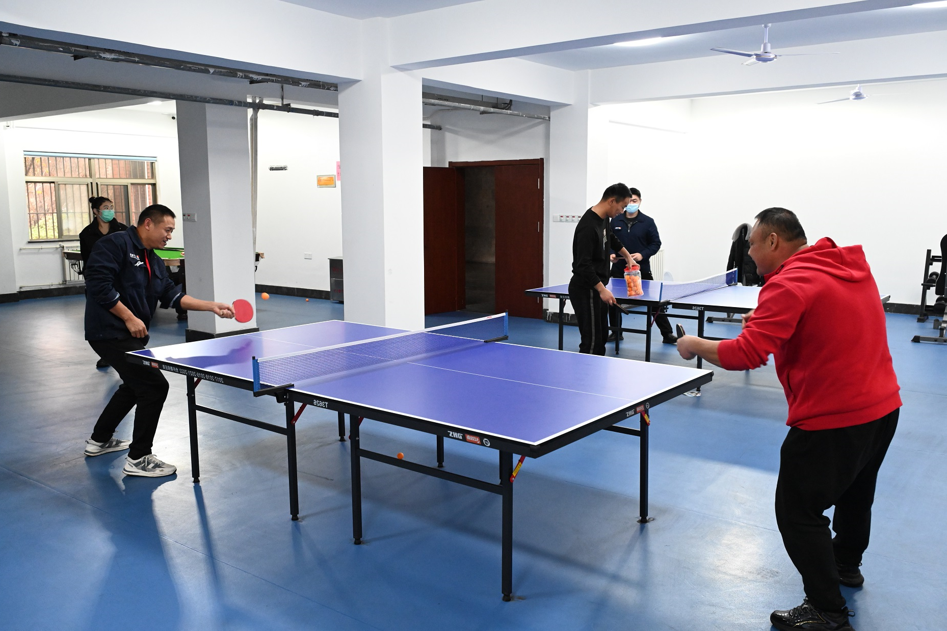 1689580877236634.jpg 图为:职工在健身活动室里进行乒乓球比赛.jpg