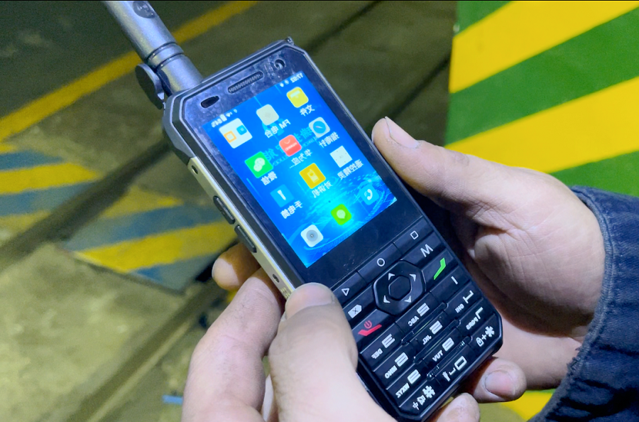 为确保作业人员在生产现场能高效沟通，义桥煤矿为井下作业人员配备了多功能防爆智能手机。图为井下使用防爆手机 （拍摄：李超 地点：井下）.png